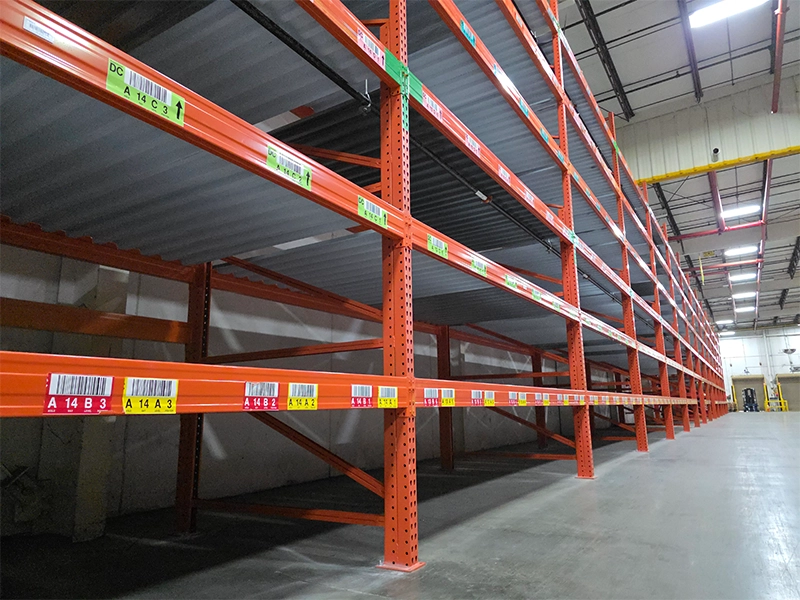 Empty industrial carpet storage racks featuring solid corrugated metal decking designed to support heavy flooring rolls.
