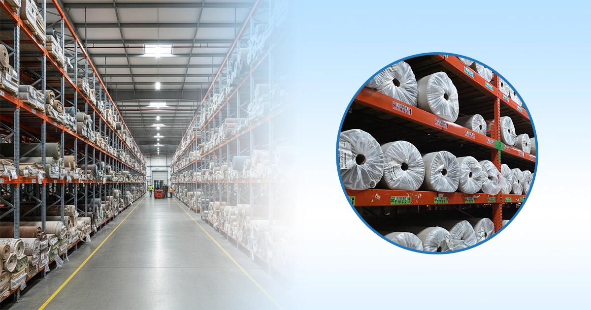 Carpet rolls are stored on industrial carpet storage racks in a large warehouse.